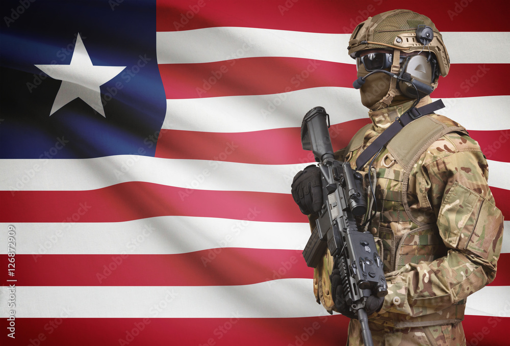 Soldier in helmet holding machine gun with flag on background series - Liberia