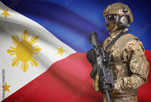 Soldier in helmet holding machine gun with flag on background series - Philippines