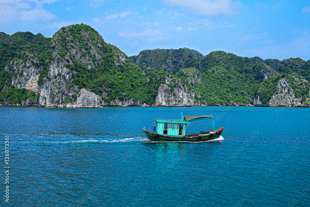 Fishing boat in Halong Bay, Vietnam, Southeast Asia. UNESCO World Heritage Site. Beautiful scenery with sea and mountain at Ha Long Bay, Vietnam. Most popular landmark, tourist destination of Vietnam.