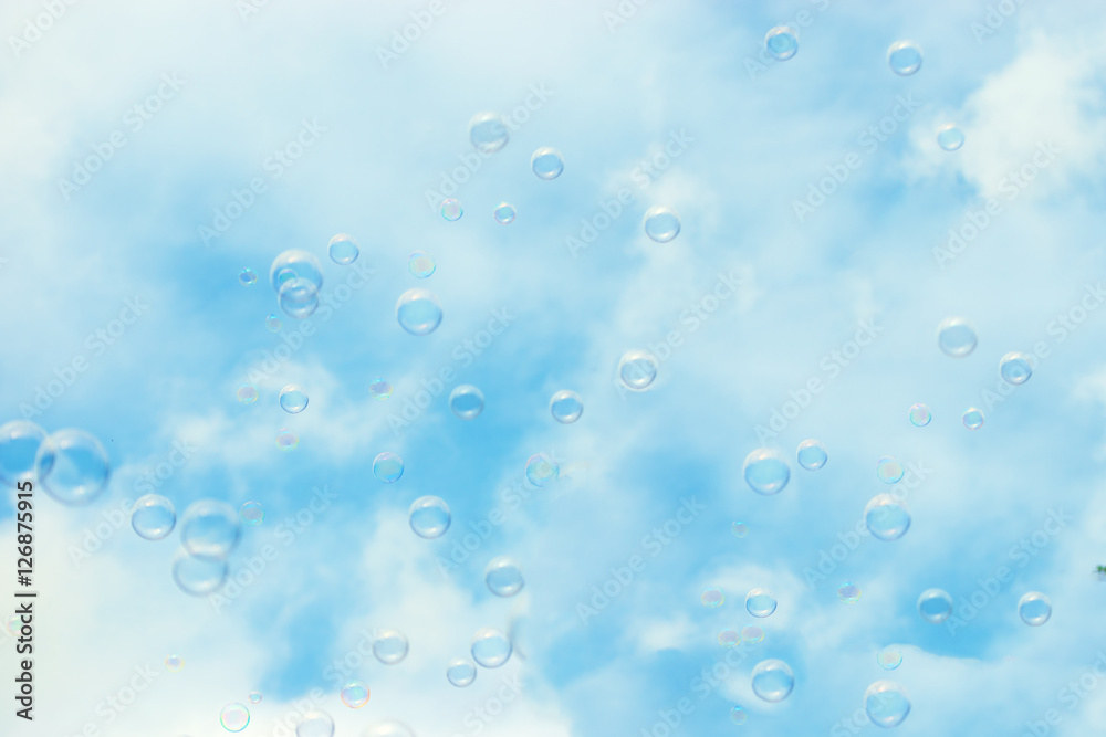 Soap bubbles floating in a blue sky background
