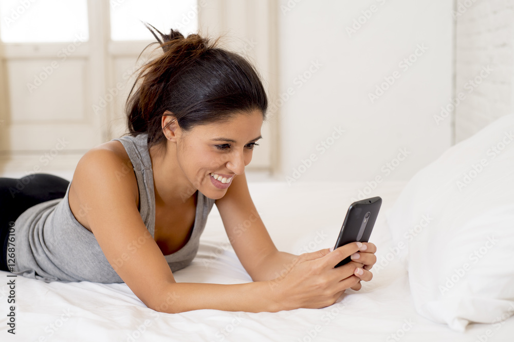 hispanic woman relaxed using internet mobile phone sending message at home bedroom smiling happy hispanic woman relaxed using internet mobile phone sending message at home bedroom smiling happy