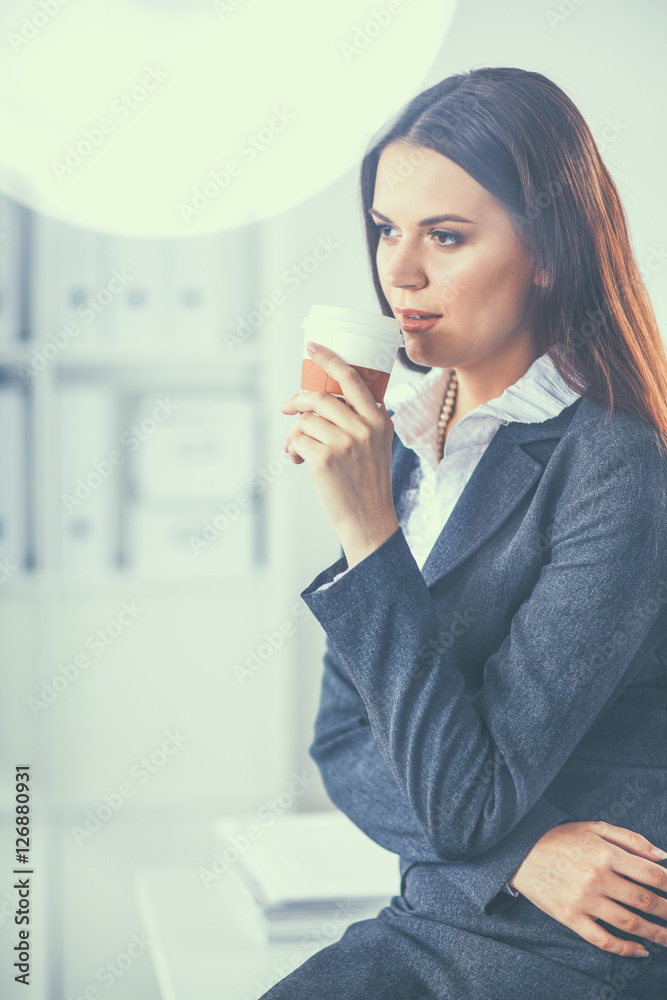 Beautiful businesswoman enjoying coffee in bright office Beautiful businesswoman enjoying coffee in bright office