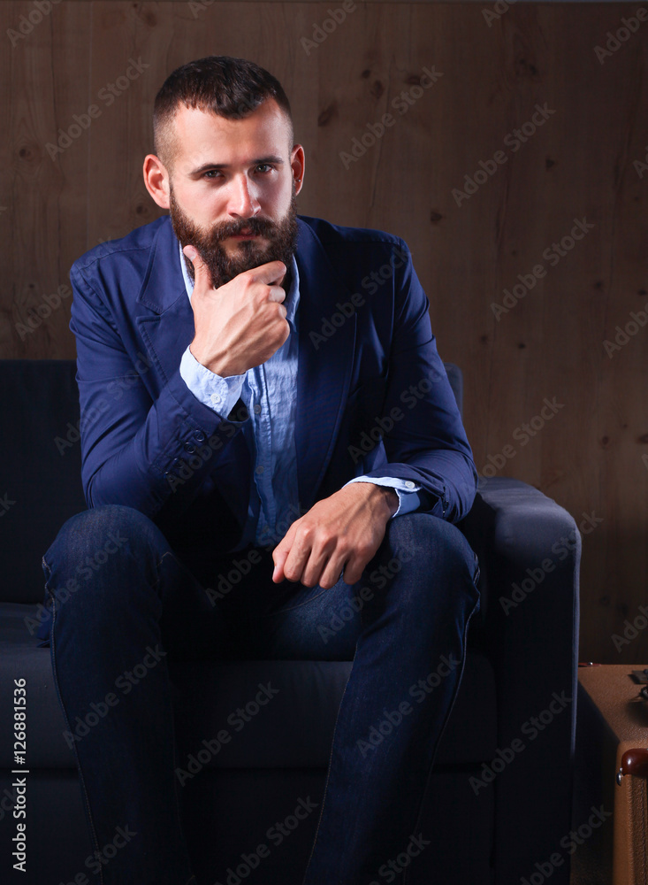 Young businessman sitting on chair in office Young businessman sitting on chair in office