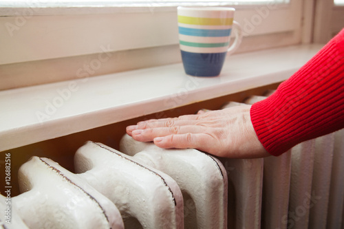 touching the radiator to check whether heated photo