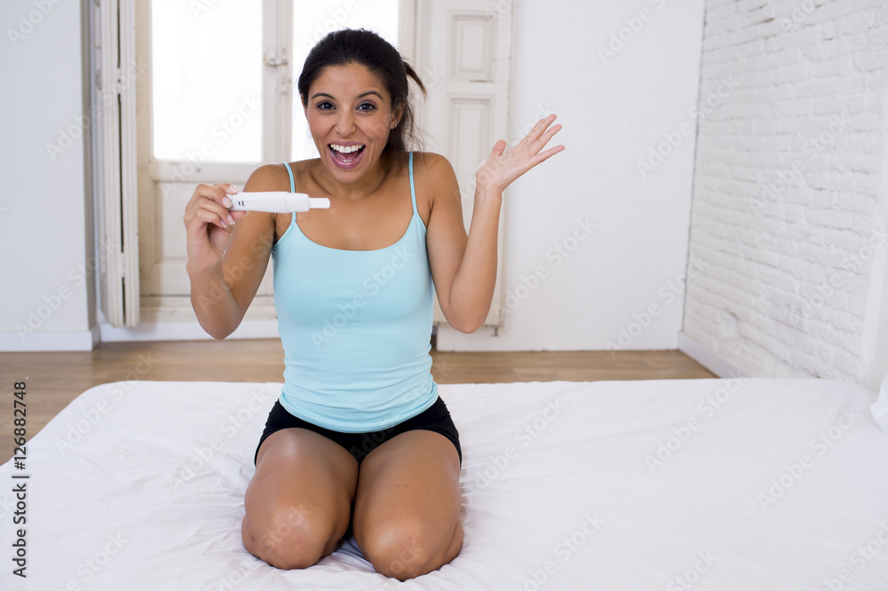 beautiful latin woman holding pregnancy test looking and finding positive result smiling happy and excited beautiful latin woman holding pregnancy test looking and finding positive result smiling happy and excited