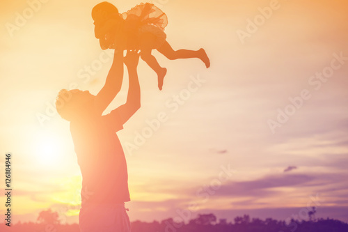 Father took the baby learn to walk at sunset.