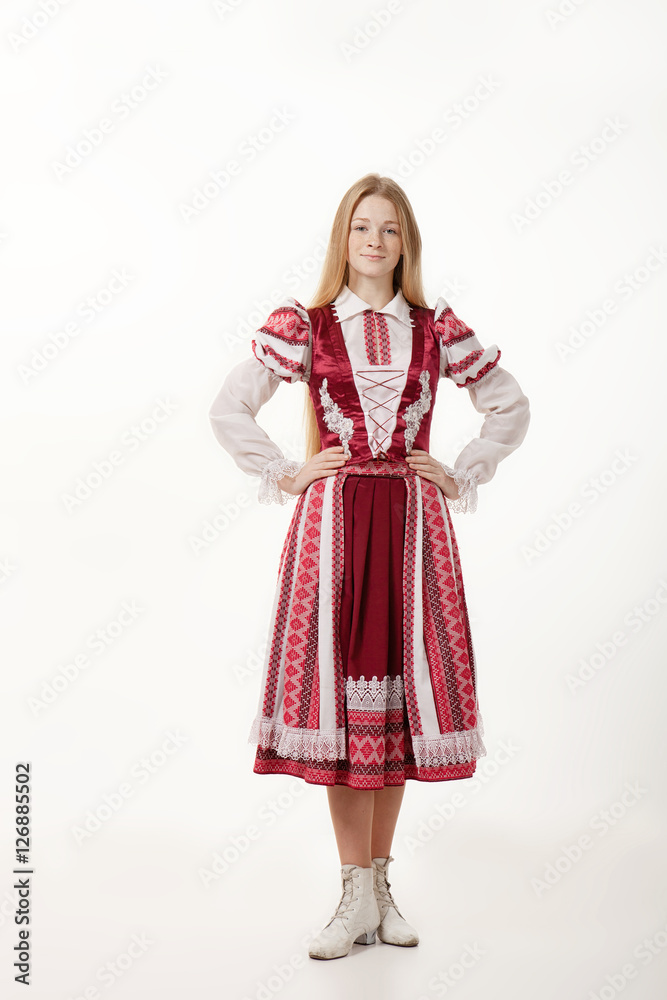 Young beautiful redhead woman dancer in traditional folk costume posing isolated on white background
