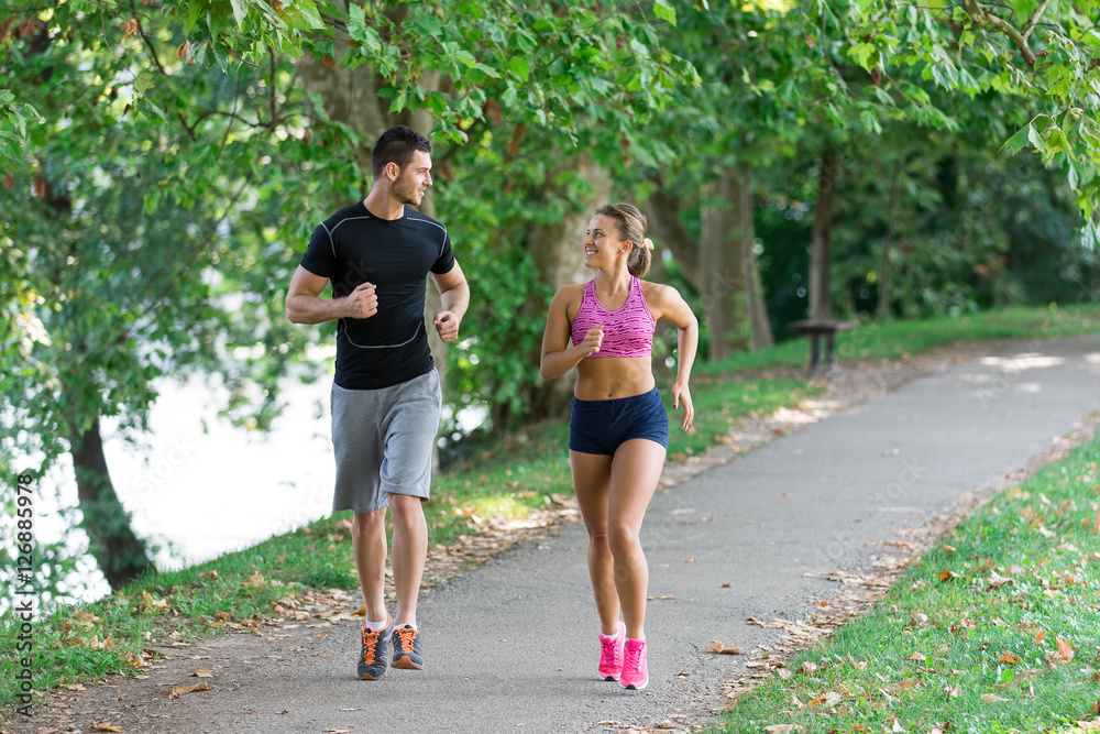 Fototapeta premium Young couple running in early morning at the park