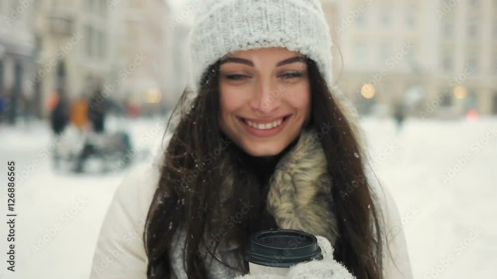 happiness, winter holidays, christmas, beverages and people concept - Cheerful gorgeous brunette in winter fashion holding disposable cup on urban background happiness, winter holidays, christmas, beverages and people concept - Cheerful gorgeous brunette in winter fashion holding disposable cup on urban background