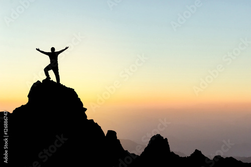 Silhouette of a man on a mountain top. Sport and active life concept