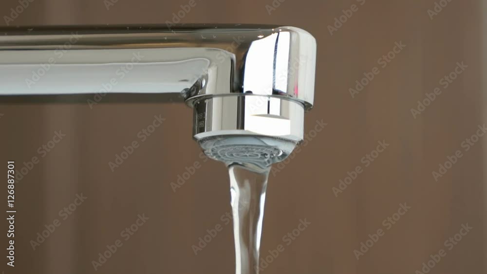 Water under weak pressure flows from a water tap Water under weak pressure flows from a water tap