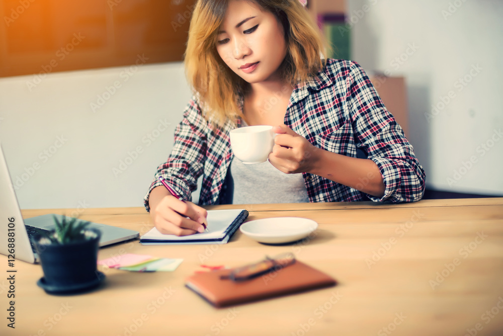 business woman writing something on notepad in office. business woman writing something on notepad in office.