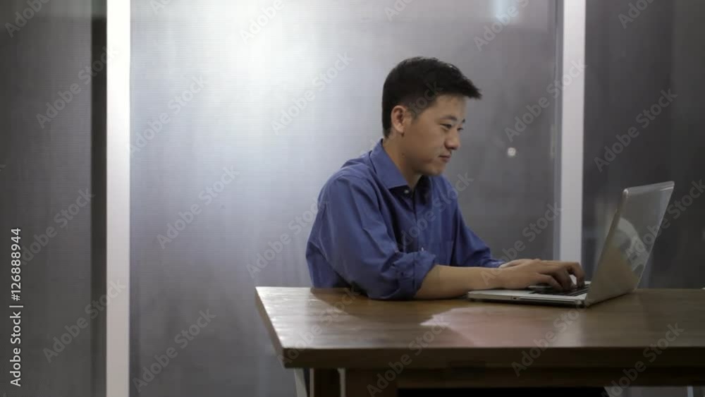 MS Man working on laptop sitting by window / China MS Man working on laptop sitting by window / China