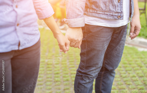 A young couple holding hands. In Nature sunrise