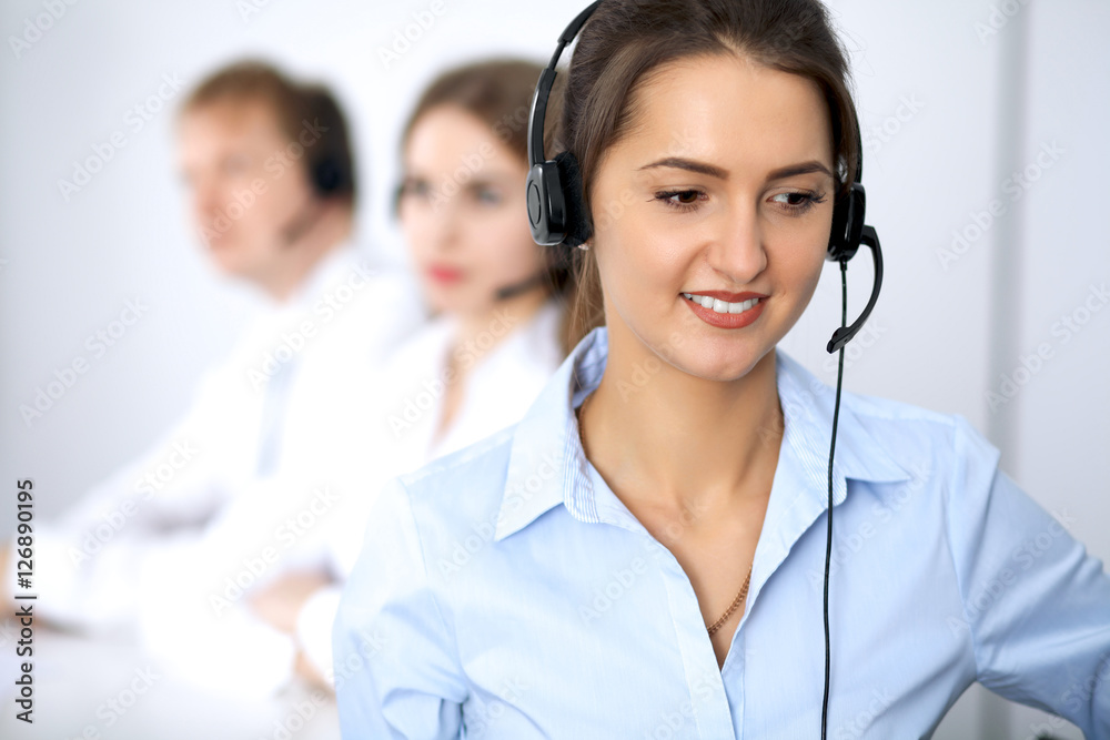 Call center. Focus on beautiful woman in headset Call center. Focus on beautiful woman in headset