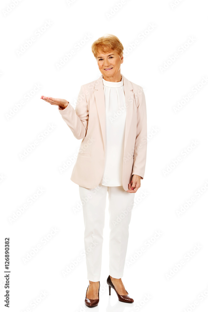 Smile senior woman holding something on open palm Smile senior woman holding something on open palm