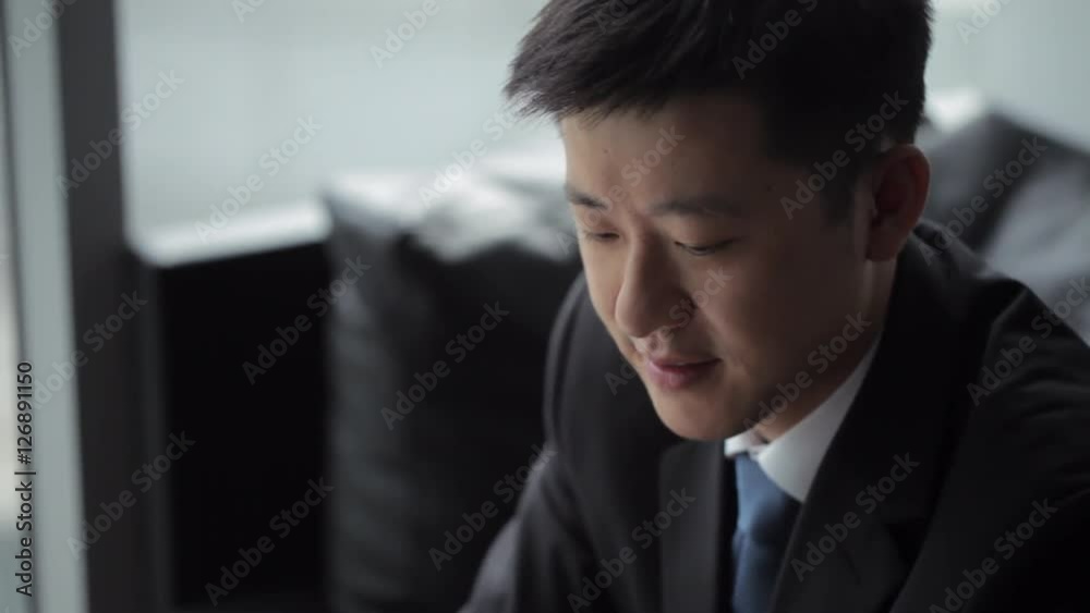 TU CU Businessman using digital tablet in front of window / Beijing, China TU CU Businessman using digital tablet in front of window / Beijing, China