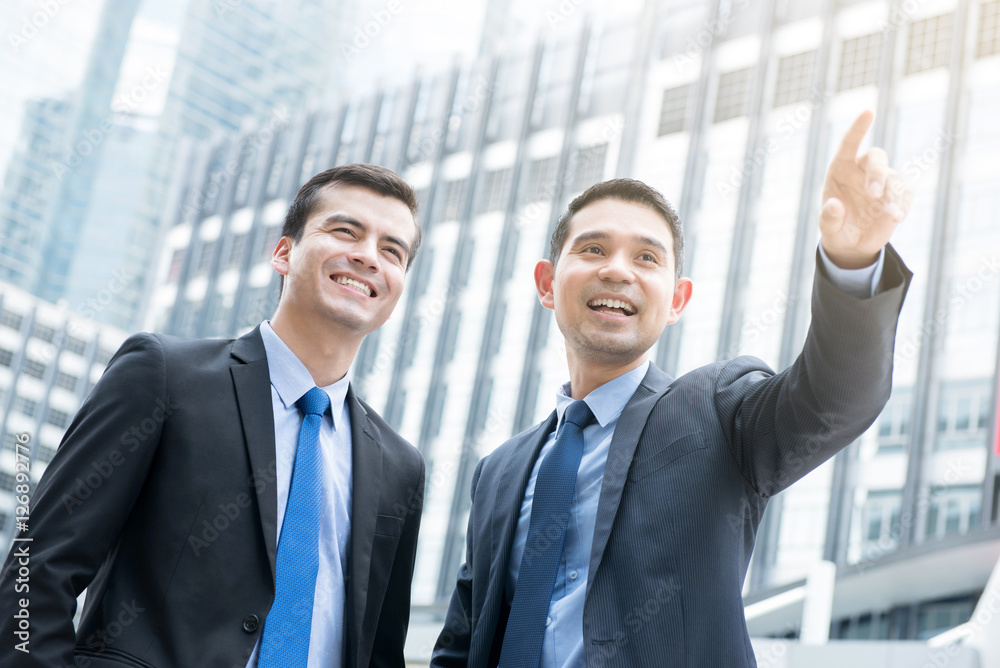 Two businessmen standing outdoors in the city Two businessmen standing outdoors in the city