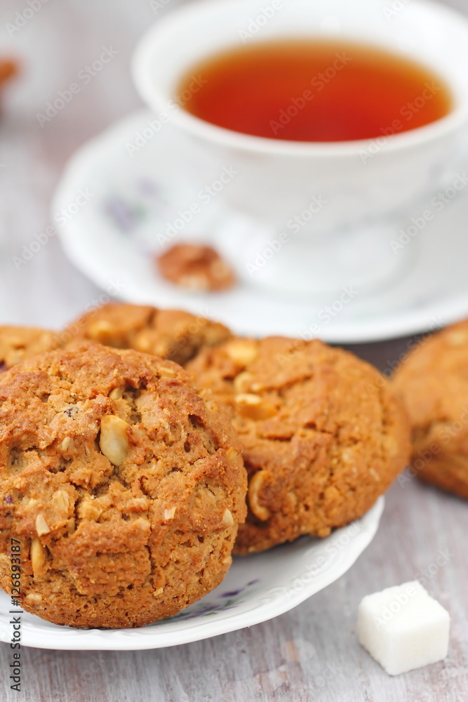 Cup of tea and oatmeal cookies with nuts, raisins cinnamon Cup of tea and oatmeal cookies with nuts, raisins cinnamon