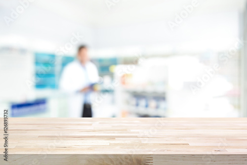 Empty wood counter top on blur pharmacy  background photo