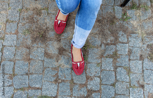 Womens foot close up in jeans and red loafers