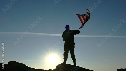 Soldier silhouette and American Flag in Slow Motion. Sunrise time. 