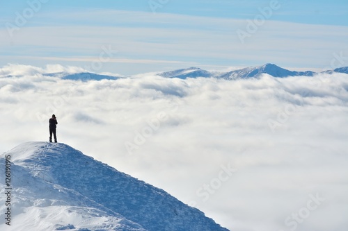 landscape with one photographer on the top in winter mountain