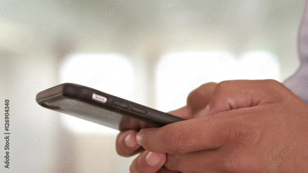 Close up of male hands sms messaging on smart phone. Man messaging and typing on smartphone Close up of male hands sms messaging on smart phone. Man messaging and typing on smartphone