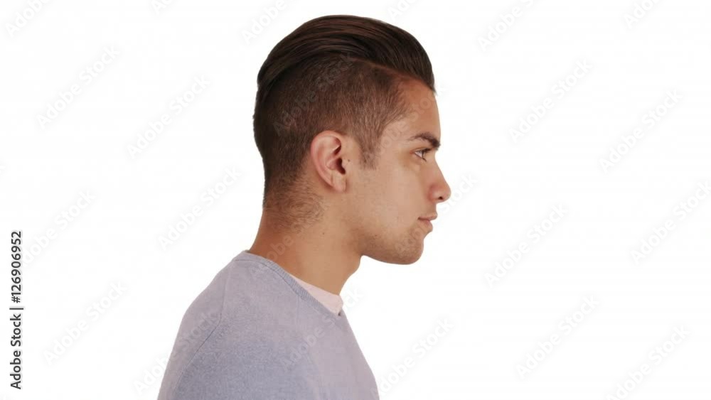 Side view of Hispanic man with cool undercut standing with white background. Profile close up portrait of Latino millennial Side view of Hispanic man with cool undercut standing with white background. Profile close up portrait of Latino millennial