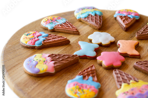 Cookies on a wooden board. Colorful glazed biscuits. Holiday desserts for kids. Pastry with sugar frosting.