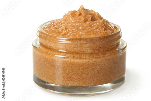 Body scrub of ground coffee and sugar in jar on white isolated background. Homemade cosmetic for peeling and spa care.