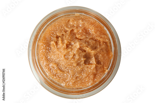 Body scrub of ground coffee and sugar in jar on white isolated background. Homemade cosmetic for peeling and spa care. Top view.