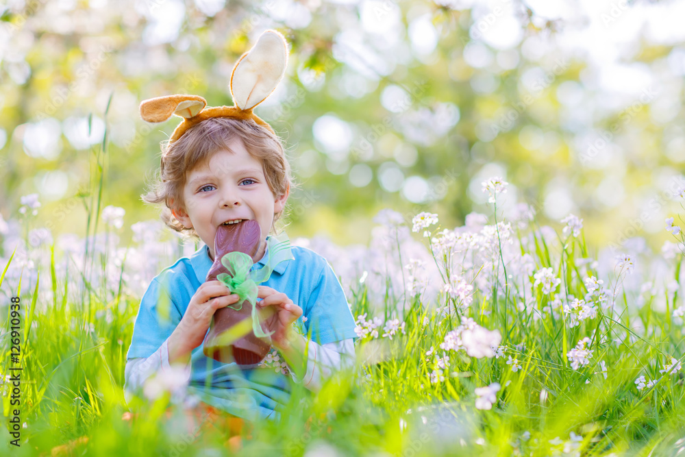 Little kid with Easter bunny ears and chocolate Little kid with Easter bunny ears and chocolate