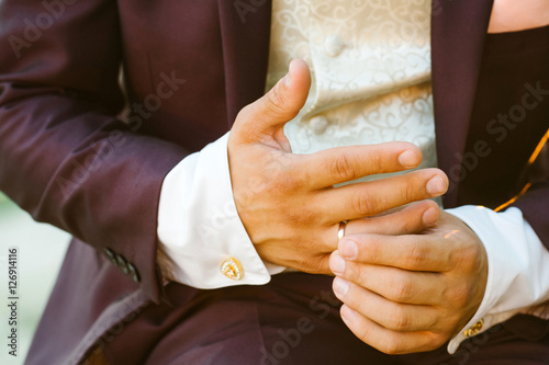 Male groom hands with ring