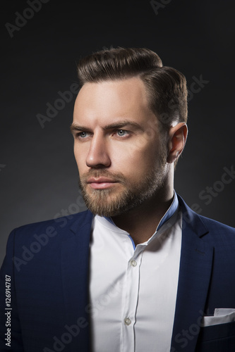 Portrait of a business man with perfect hair style over dark background photo