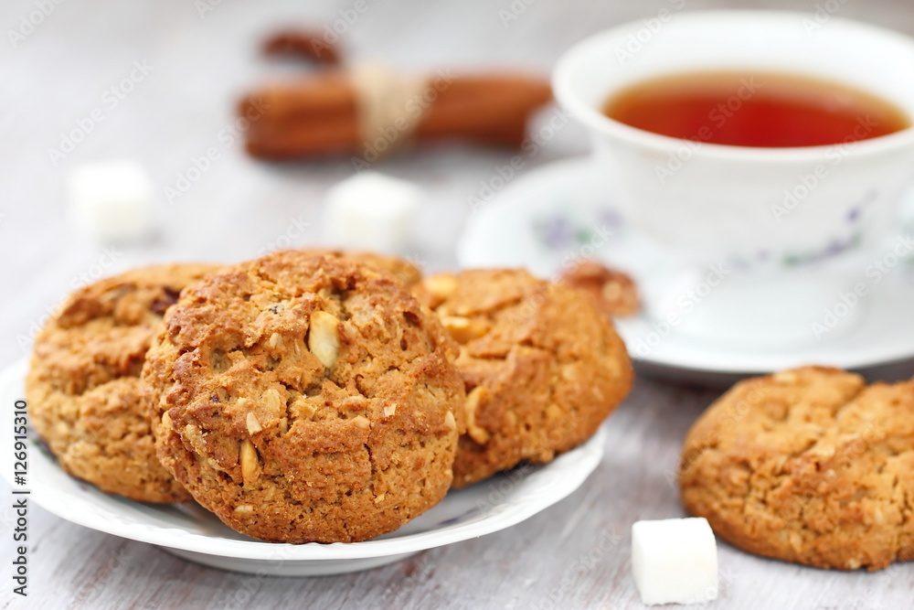 Cup of tea and oatmeal cookies with nuts, raisins cinnamon Cup of tea and oatmeal cookies with nuts, raisins cinnamon
