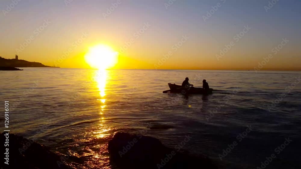 Boat with immigrants in sea at sunset - 4K
