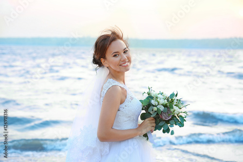 Beautiful bride on bank of ...