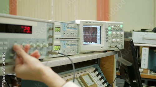 Equipment for measuring electrical signals is in the physical laboratory. The scoreboard lit instrumentation data. Oscilloscope and a pulse generator working together.