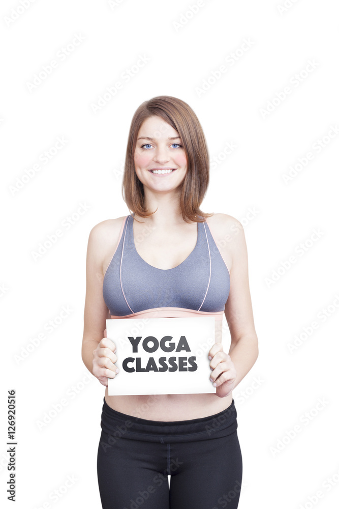 Sporty young woman holding paper saying Yoga Classes Sporty young woman holding paper saying Yoga Classes