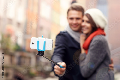 Young couple taking pictures with sefie stick photo