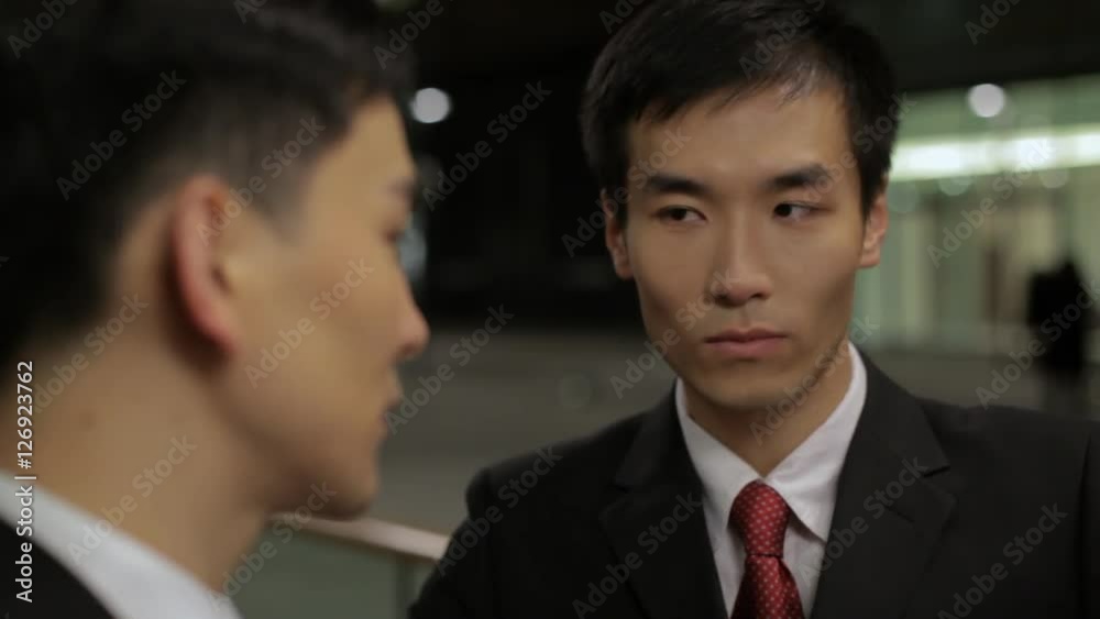 CU SELECTIVE FOCUS Two business man talking on street at night / China CU SELECTIVE FOCUS Two business man talking on street at night / China