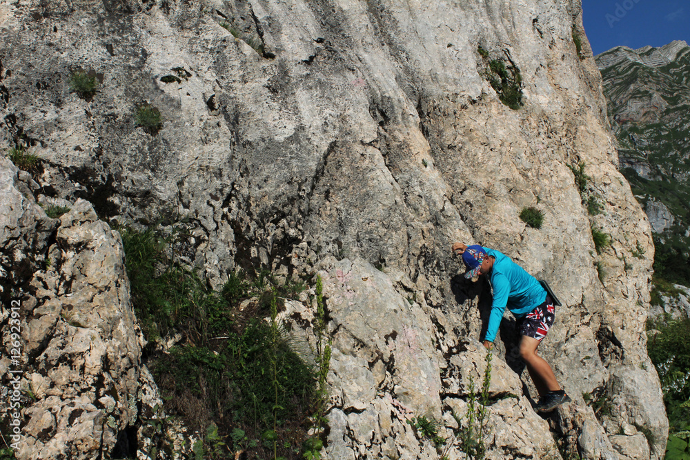 Teenager climbs the high, dangerous rock