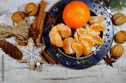 Juicy peeled tangerine on a plate on Christmas Eve
