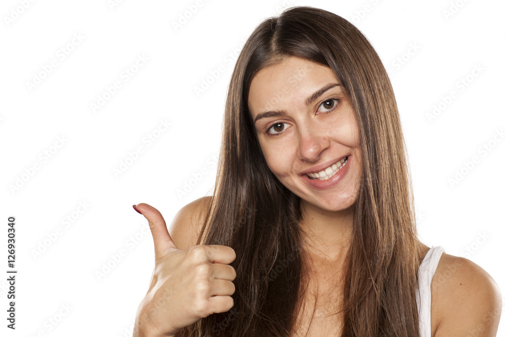 Beautiful smiling young woman without makeup showing thumbs up Beautiful smiling young woman without makeup showing thumbs up