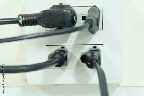 Multiple electricity plugs on adapter risk overloading and dange photo