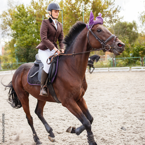 Young female rider on equestrian competition © skumer