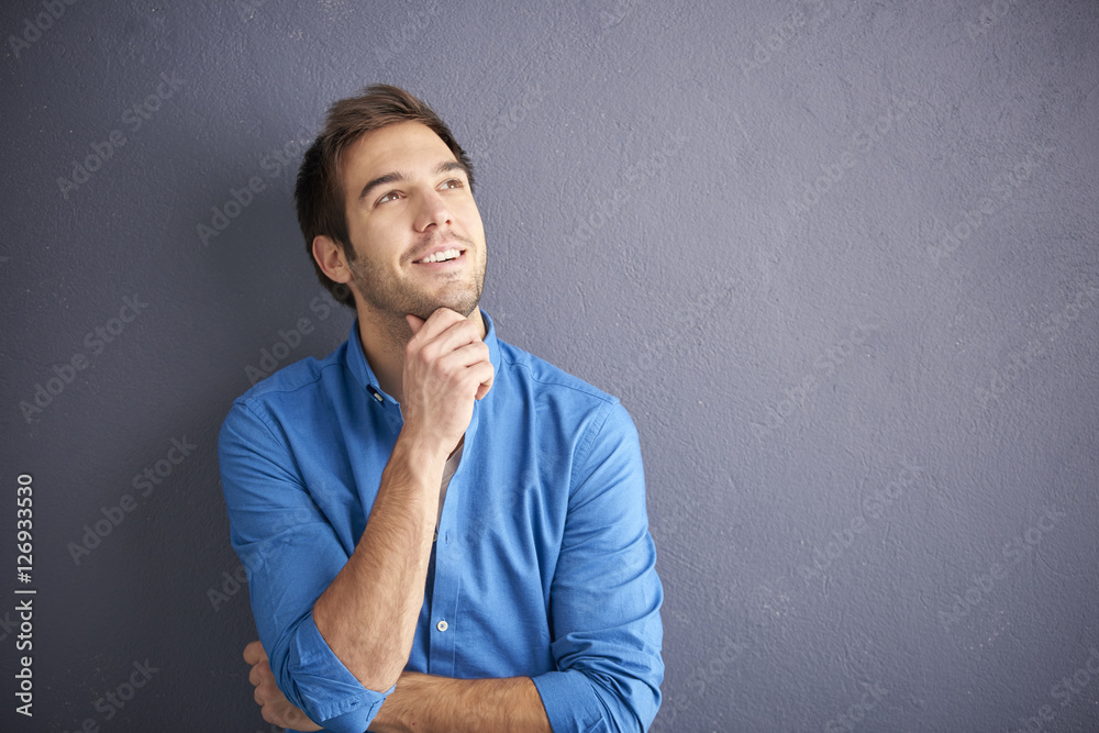 Be positive. Cropped shot of a hopful young man wearing casual clothes while standing in front of a grey wall. Be positive. Cropped shot of a hopful young man wearing casual clothes while standing in front of a grey wall.