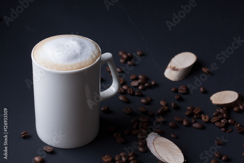 A mug of latte coffee on a black background