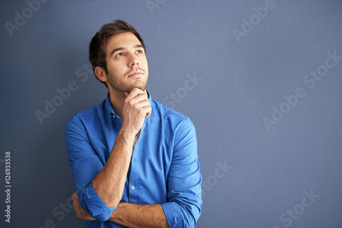 Be positive. Cropped shot of a hopful young man wearing casual clothes while standing in front of a grey wall.